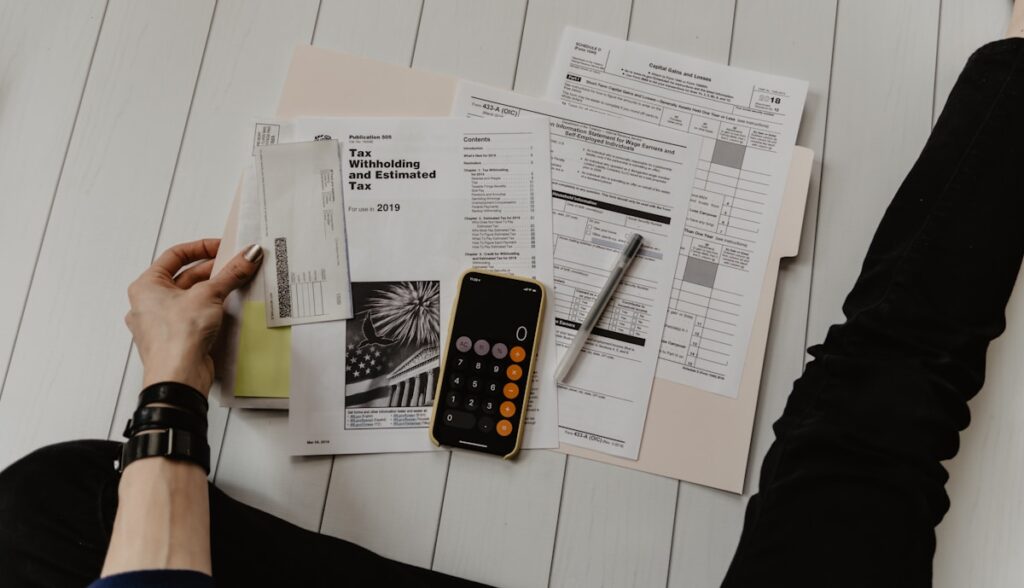 Calculator, graphs and financial documents on a desk representing bookkeeping and accounting work from home