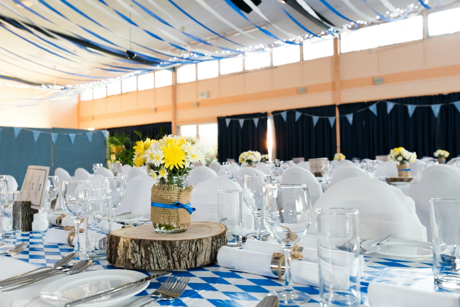 Event planner reviewing a wedding reception setup with elegant table decorations and floral centerpieces