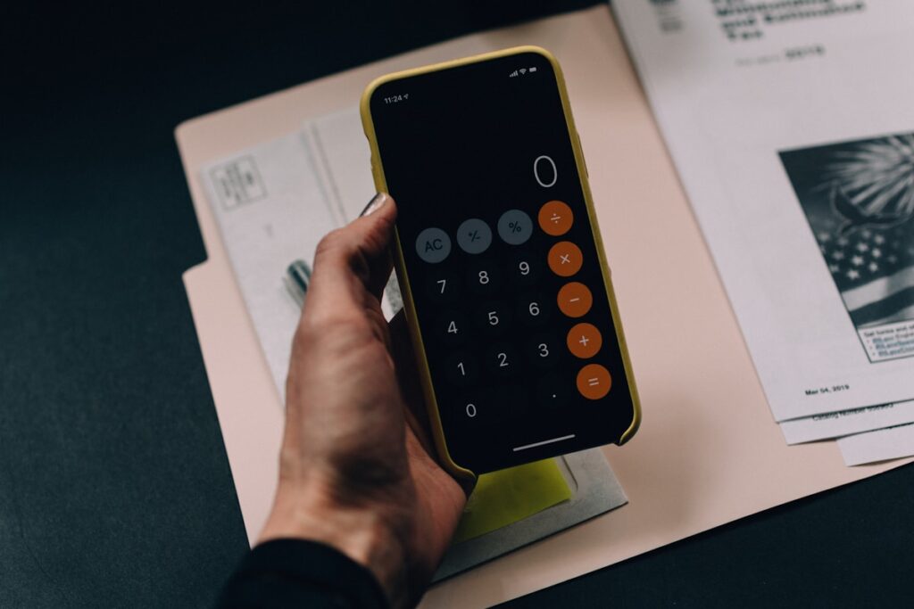 Calculator, receipts and financial documents on a desk - Freelance Bookkeeping Side Hustle 2026