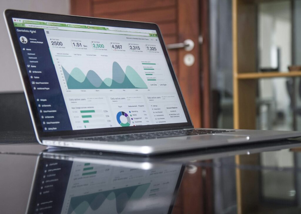 Woman working on laptop with analytics charts and social media strategy for freelance Pinterest management side hustle