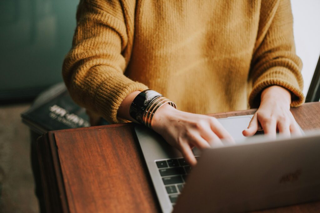 Person writing in a notebook at a desk, representing ghostwriting and freelance writing from home
