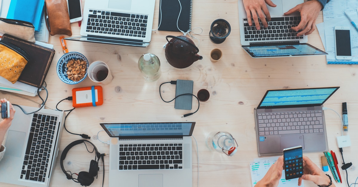 Social media management workspace with laptop and smartphone showing social media apps