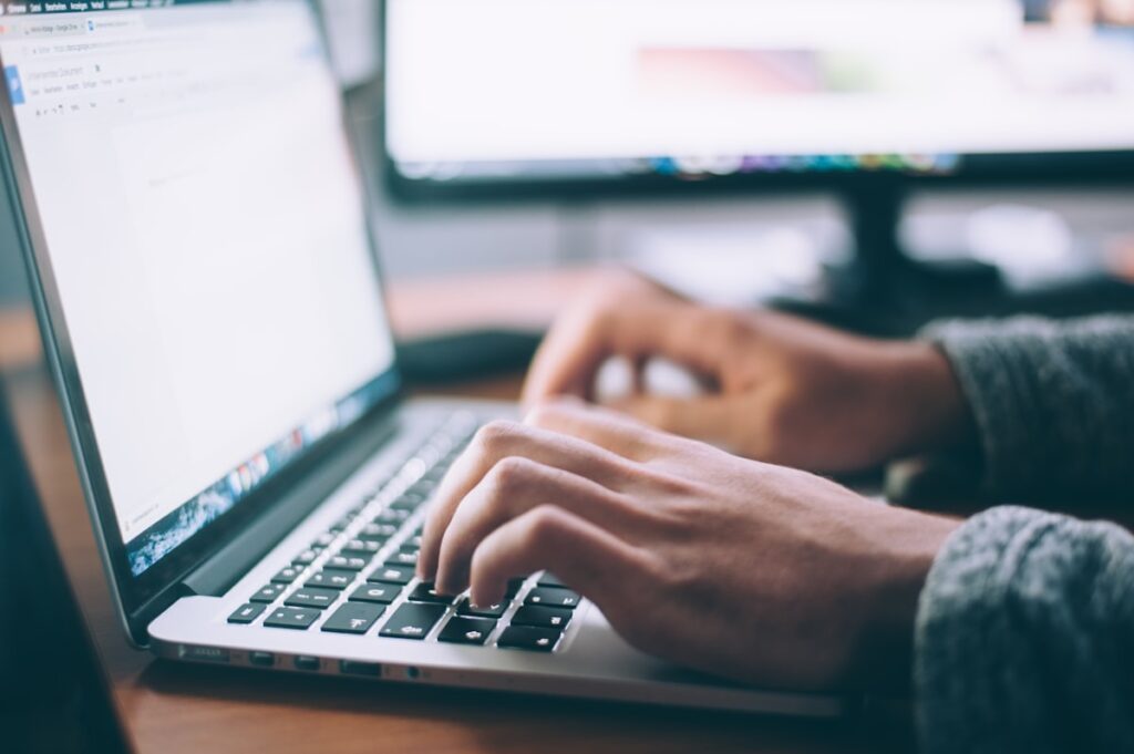 Person working remotely on a laptop as a virtual assistant side hustle